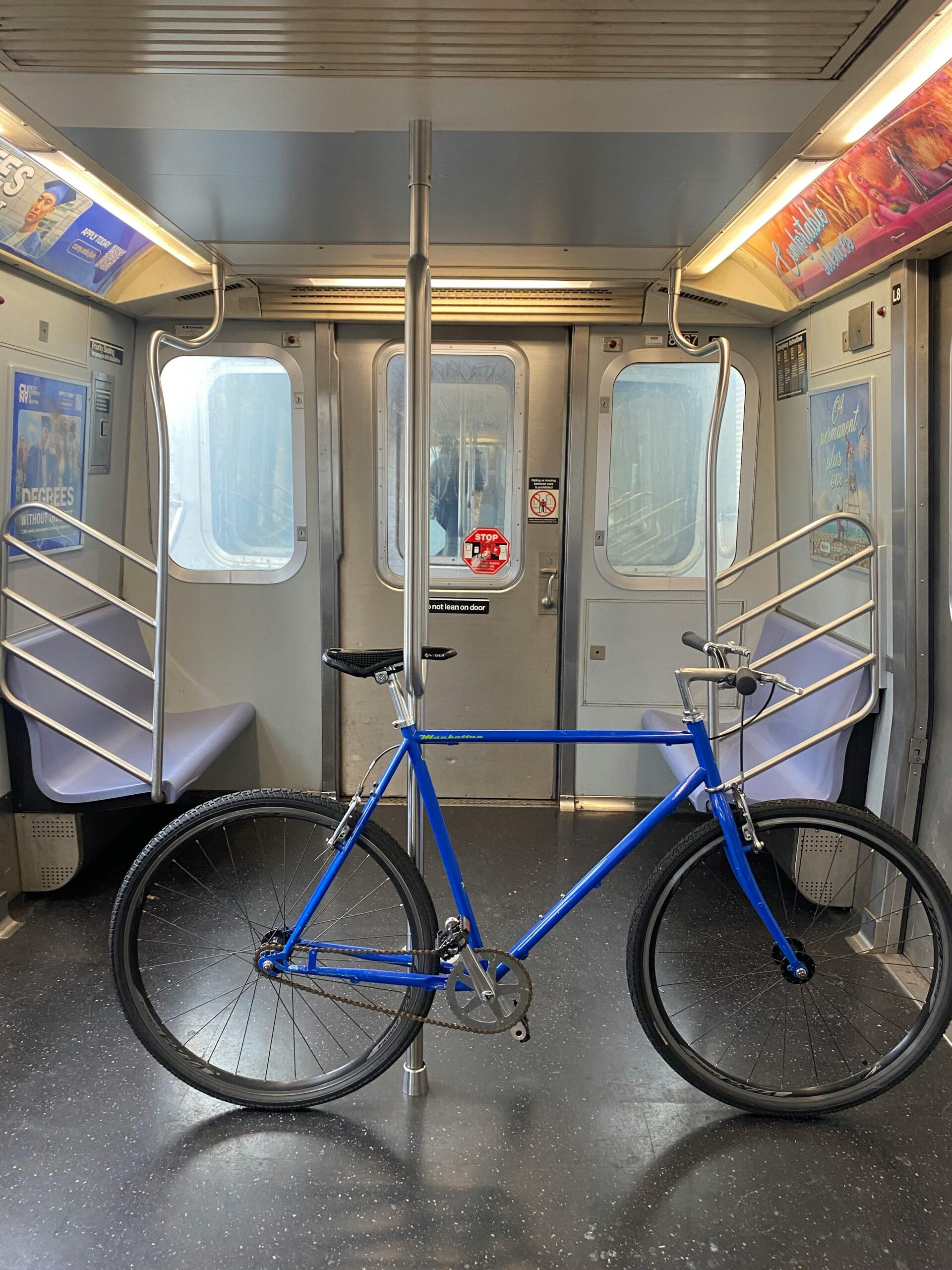 A blue bicycle placed inside an urban subway car, showcasing a unique juxtaposition of transport modes.